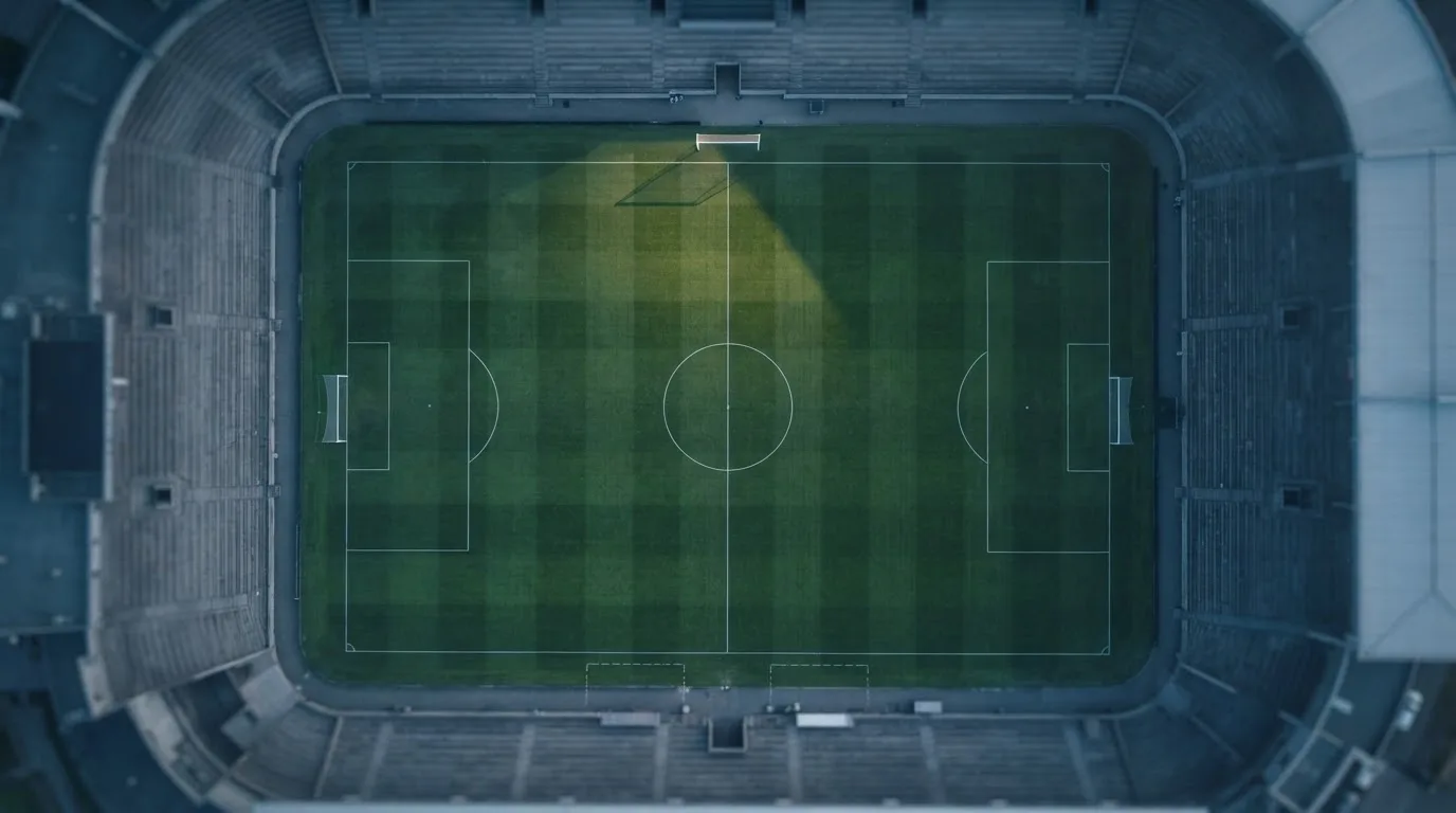 Ein Fussballplatz von oben gesehen, die Linien bilden ein helles Muster auf dem Rasen, Drohnenperspektive in der Morgendämmerung.